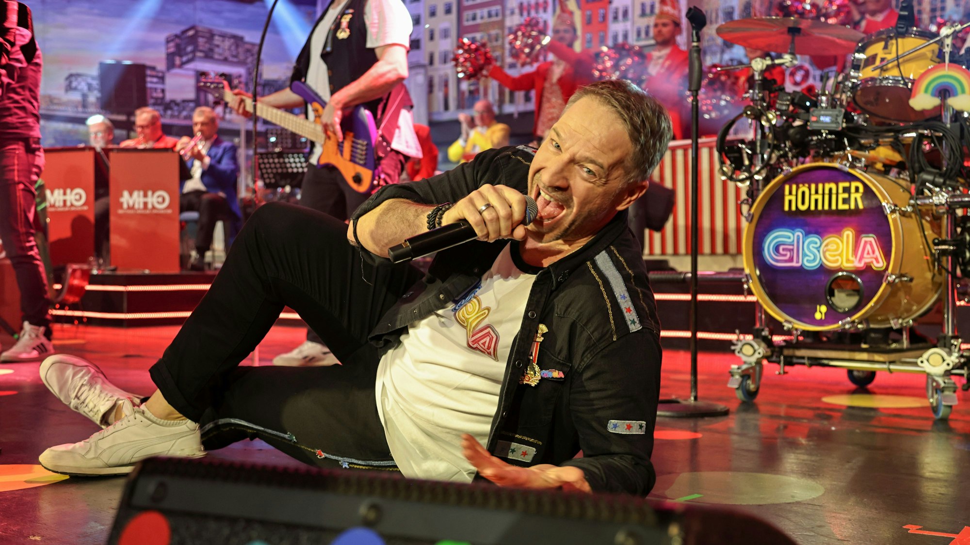 Patrick Lück von den Höhnern liegt auf der Bühne.