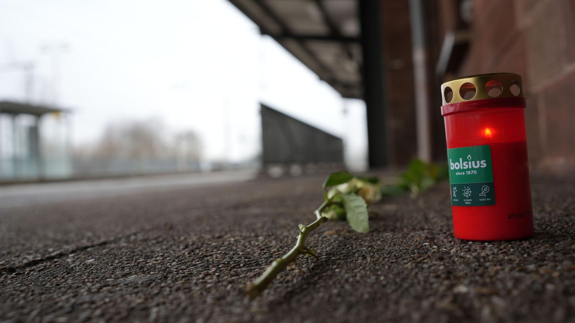Blumen und Kerzen liegen am Bahnsteig in Landstuhl.