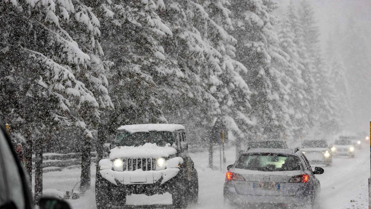 Autofahrer fahren bei starkem Schneefall auf einer Straße in der Nähe des olympischen Austragungsorts Cortina in Norditalien.