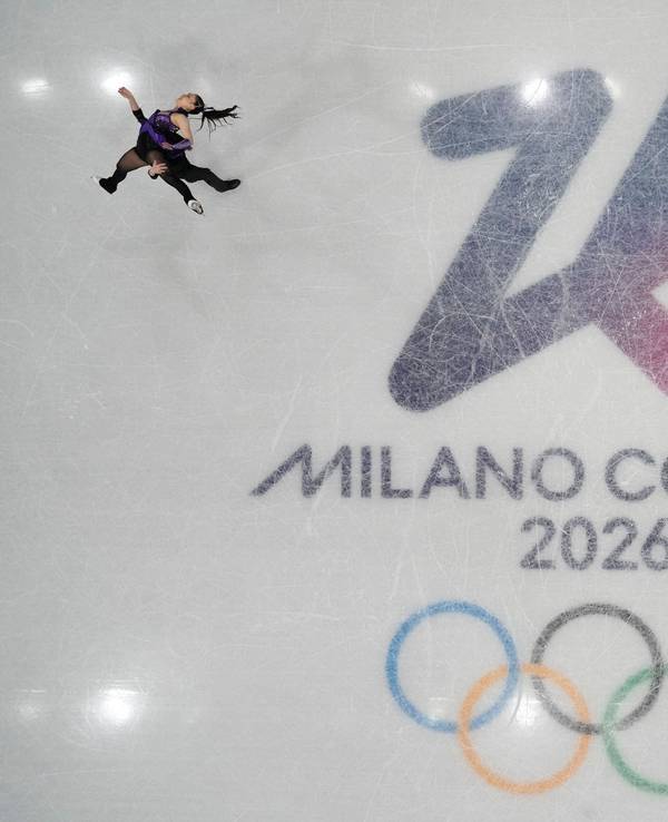 06.02.2026, Italien, Mailand: Olympia, Olympische Winterspiele Mailand Cortina 2026, Eiskunstlauf, Team, Kurzprogramm Eistanz, Utana Yoshida und Masaya Morita aus Japan laufen auf dem Eis neben den Olympischen Ringen. Foto: Bernat Armangue/AP/dpa +++ dpa-Bildfunk +++