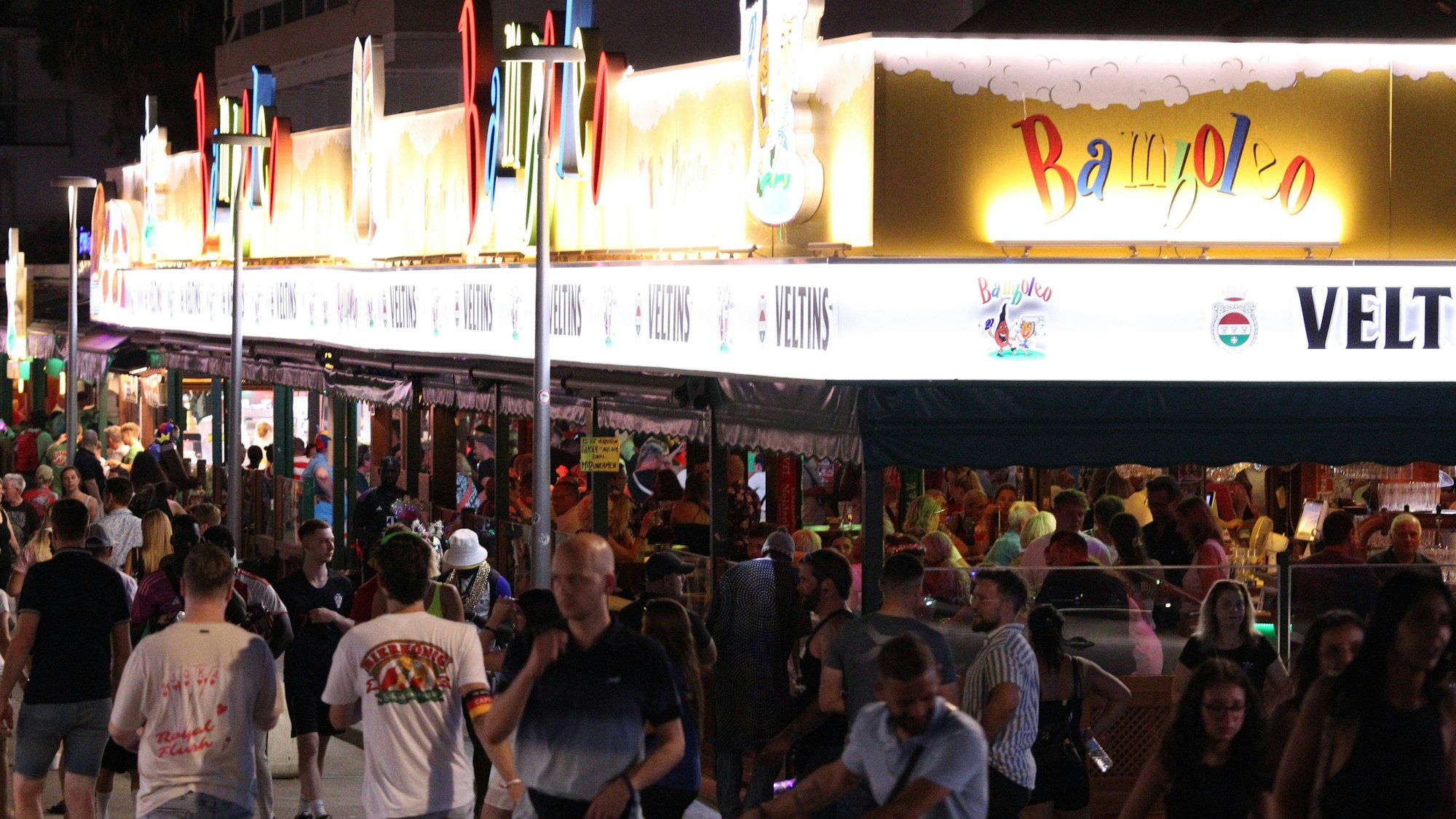 Menschen vor einer beleuchteten Bar