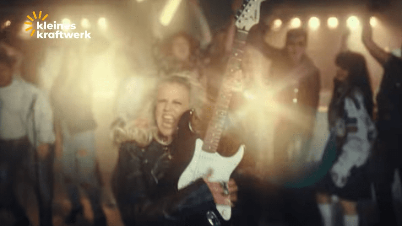 Barbara Schöneberger spielt E-Gitarre, trägt eine Lederjacke und singt im neuen Kleines Kraftwerk Werbevideo.