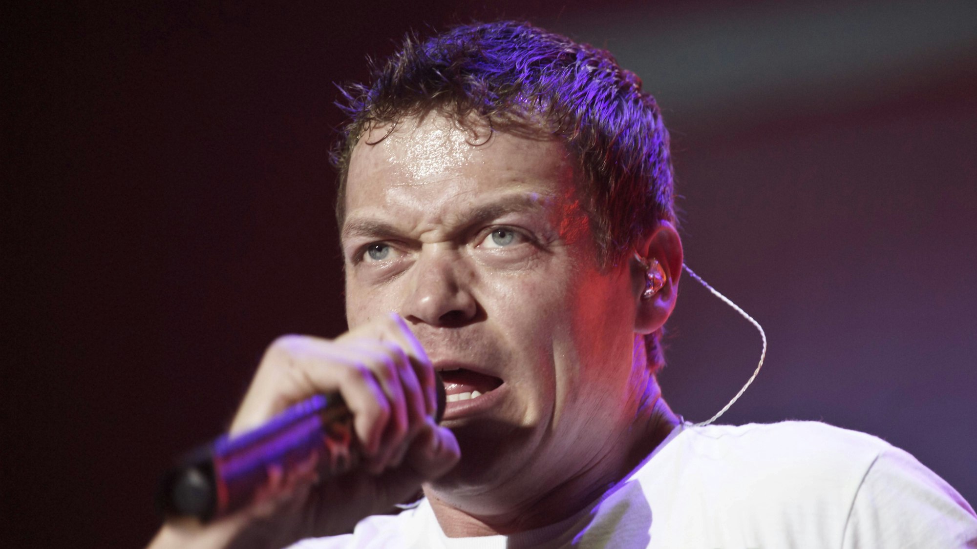 Brad Arnold singt in ein Mikrofon.