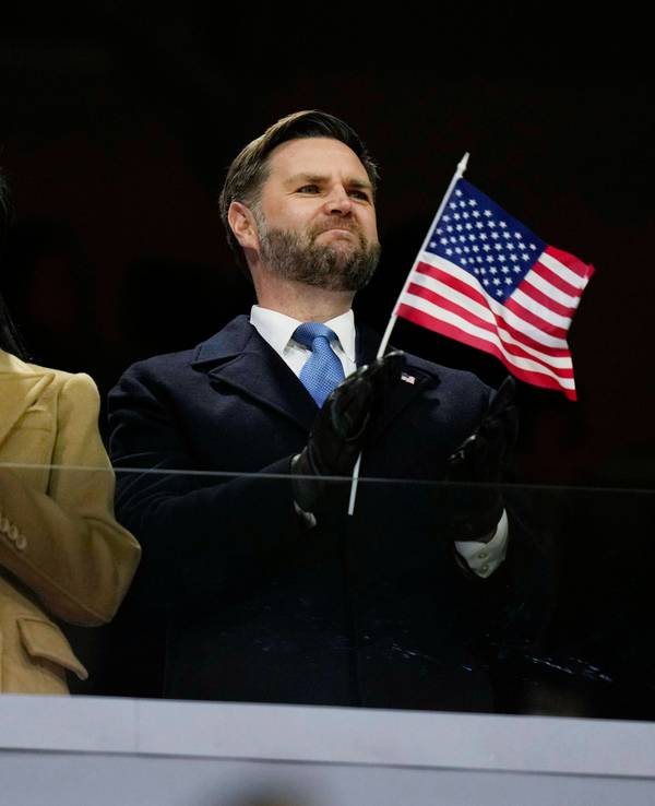 JD Vance schwenkt ein US-Fähnchen bei der Olympia-Eröffnungsfeier neben seiner Frau Usha.