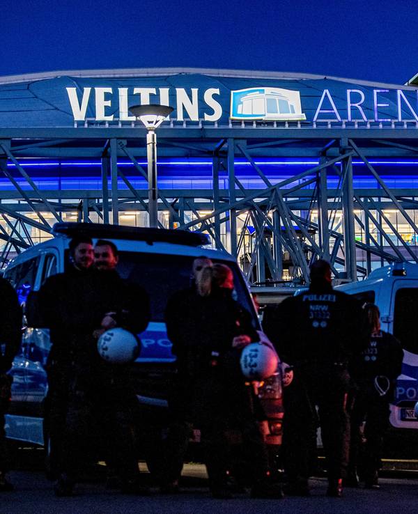 Polizisten stehen vor der Einfahrt zum Stadion.