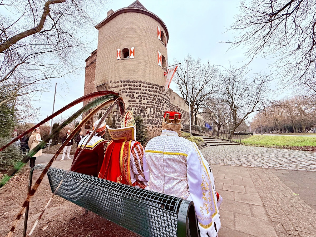 Das Kölner Dreigestirn sitzt auf seiner Bank.