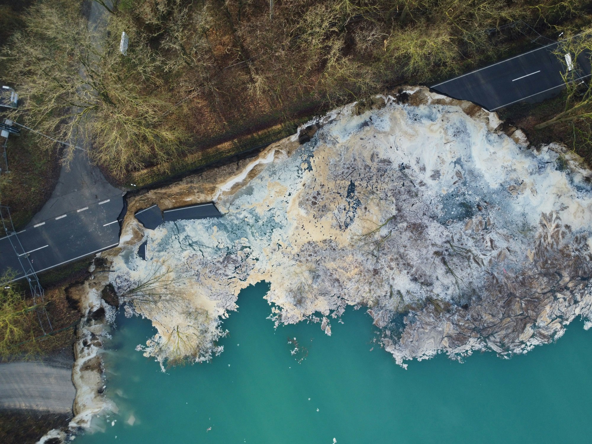 Der Asphalt einer Straße ist auf mehreren Metern weggebrochen.