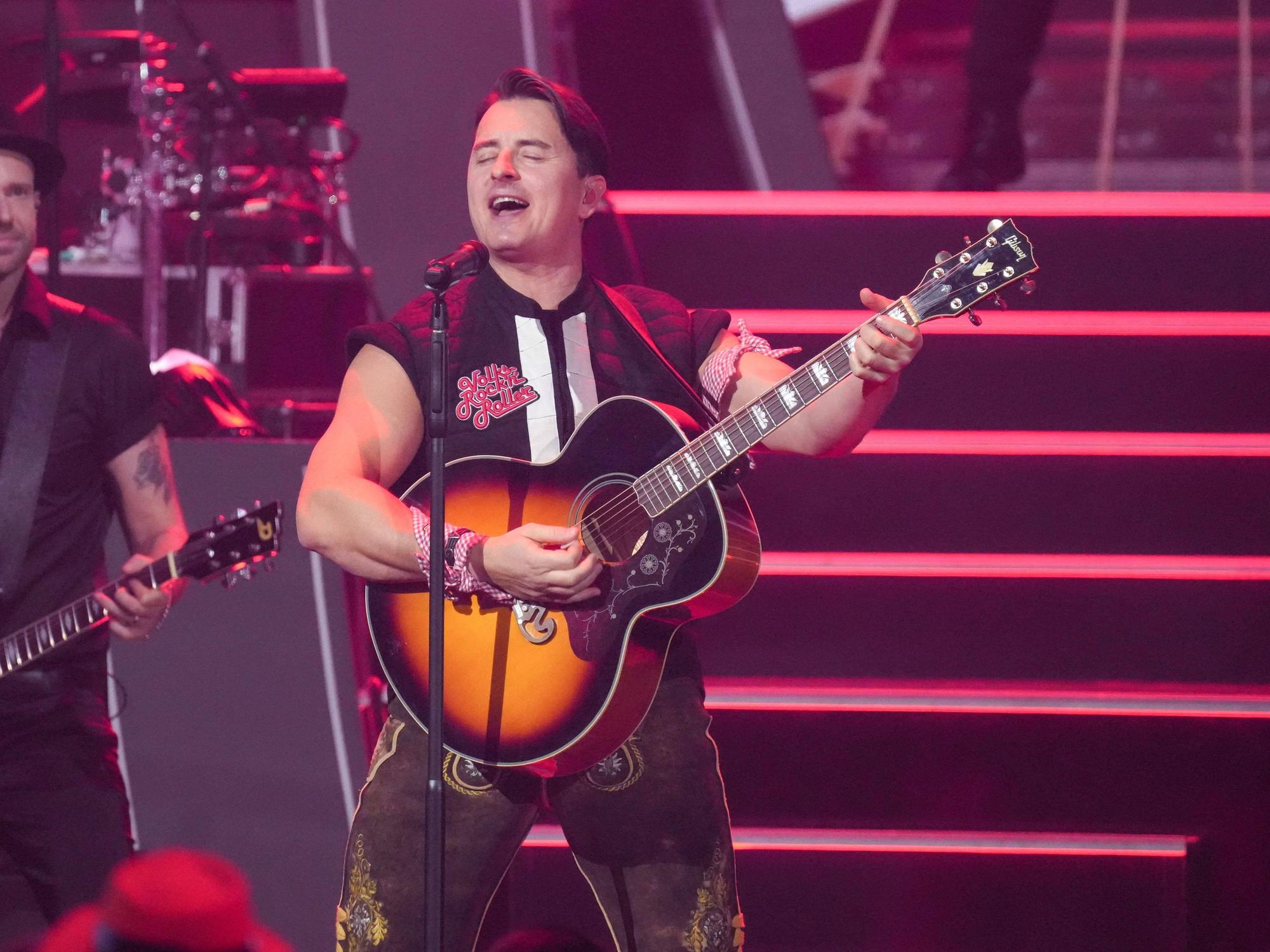Sänger Andreas Gabalier singt und spielt Gitarre.