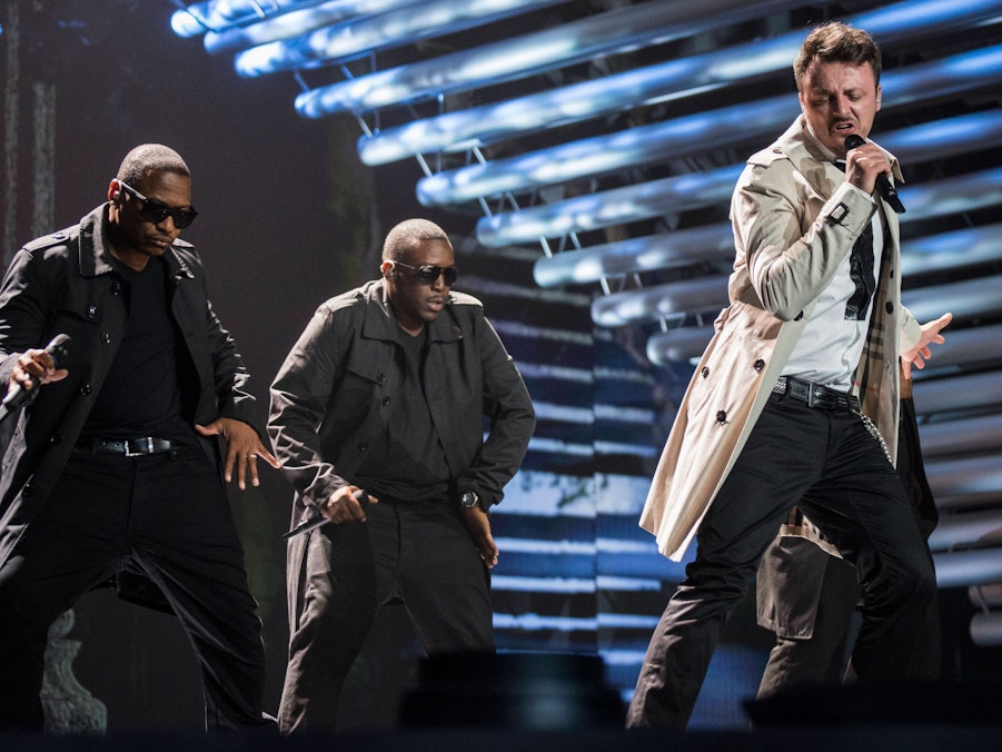 Daniel Kajmakoski und zwei Männer performen