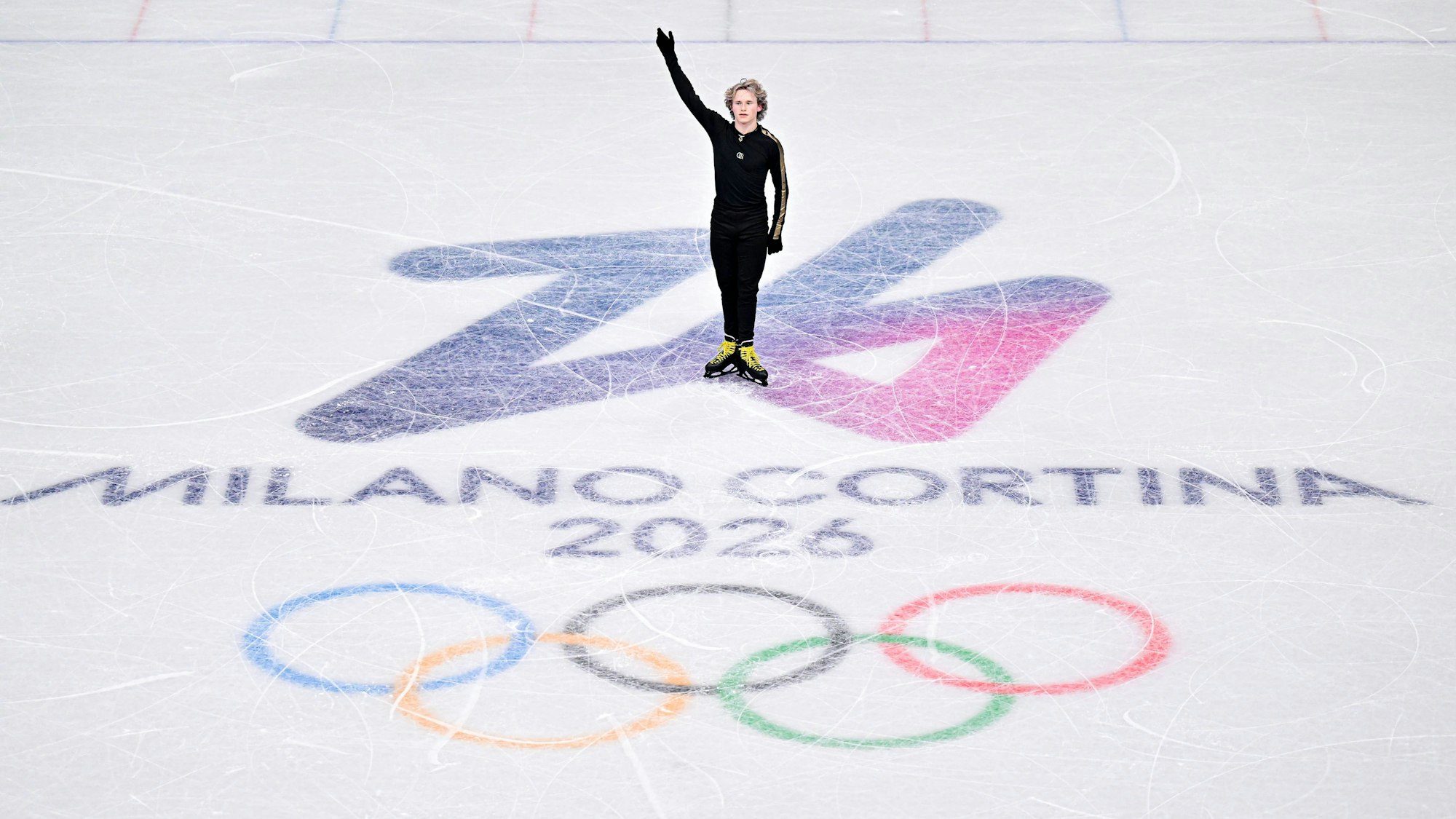 Ilia Malinin auf Eis mit Olympischen Ringen und Schriftzug