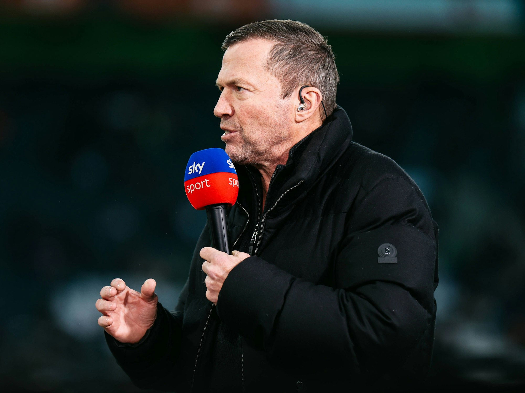 Lothar Matthäus spricht in ein Mikrofon von Sky.