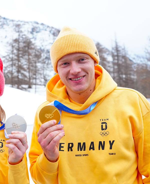 Skifahrerin Emma Aicher und Rodler Max Langehan posieren gemeinsam mit ihren Olympia-Medaillen.