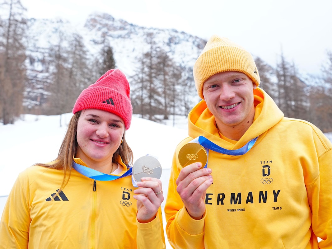 Skifahrerin Emma Aicher und Rodler Max Langehan posieren gemeinsam mit ihren Olympia-Medaillen.