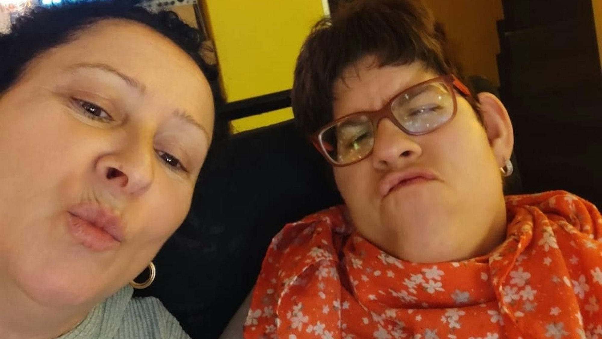 Mutter und Tochter machen einen Kussmund.