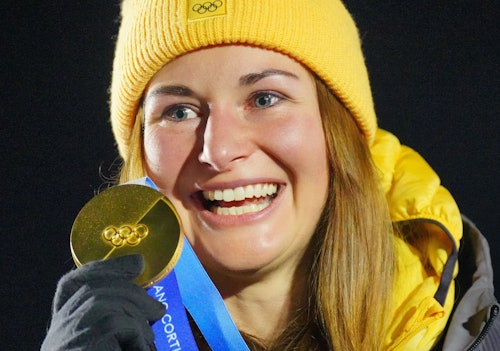 Julia Taubitz zeigt voller Stolz ihre Goldmedaille.
