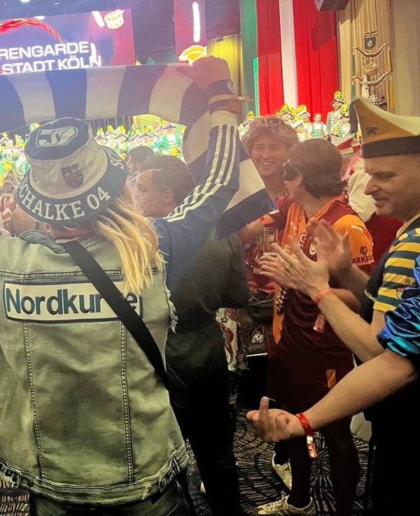 Ein Schalke-Fan hält einen blau-weißen Schal im Publikum hoch.