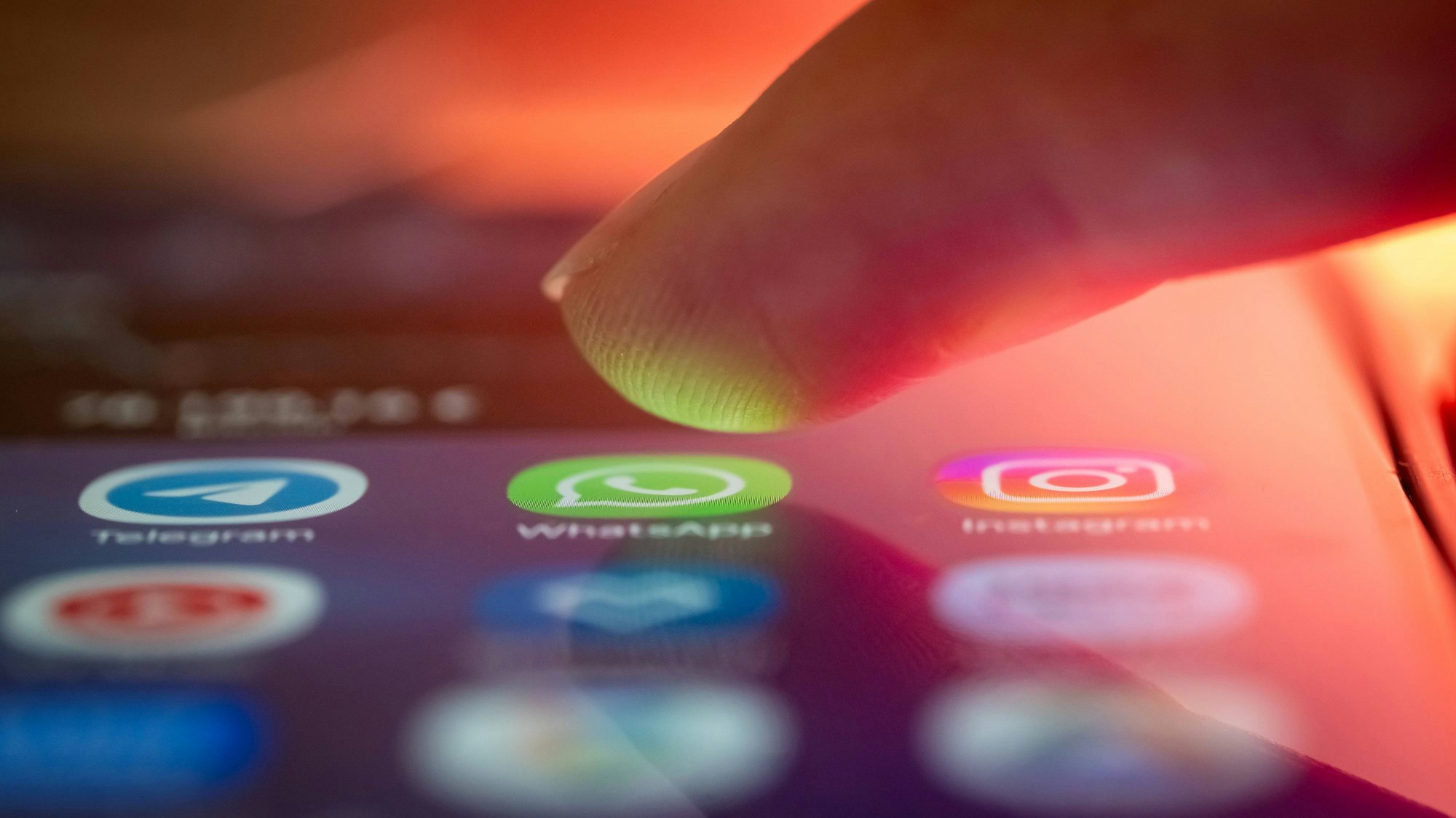 Finger auf Smartphone mit App-Symbolen