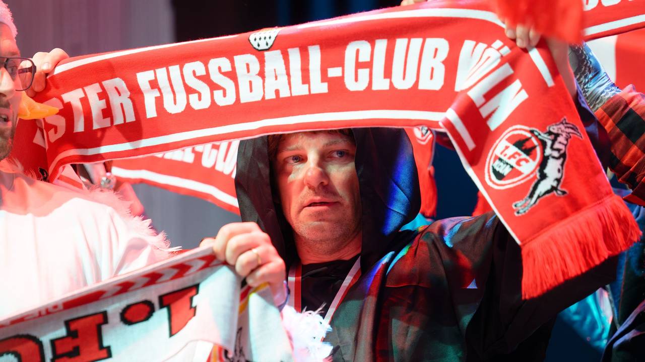 Trainer Lukas Kwasniok hält einen FC-Schal hoch.