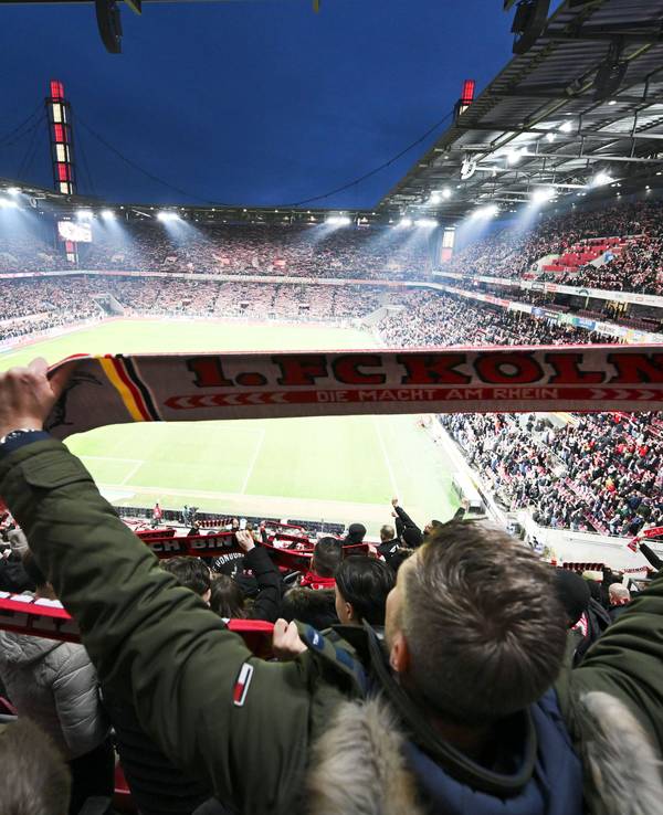 Kölner Fans halten ihre Schals beim Singen der Vereinshymne.