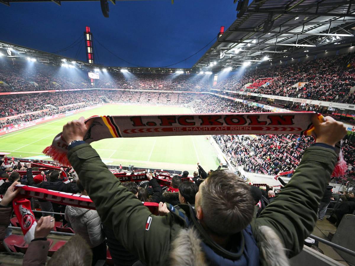 Kölner Fans halten ihre Schals beim Singen der Vereinshymne.