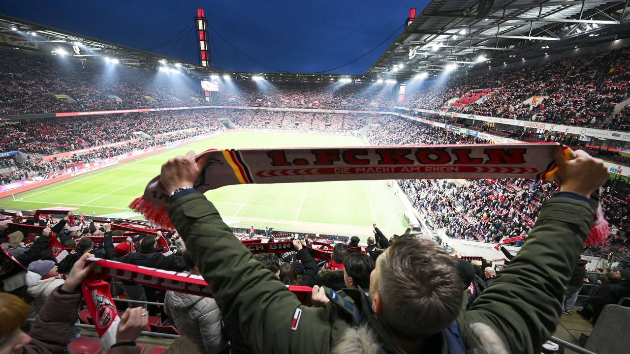 Kölner Fans halten ihre Schals beim Singen der Vereinshymne.