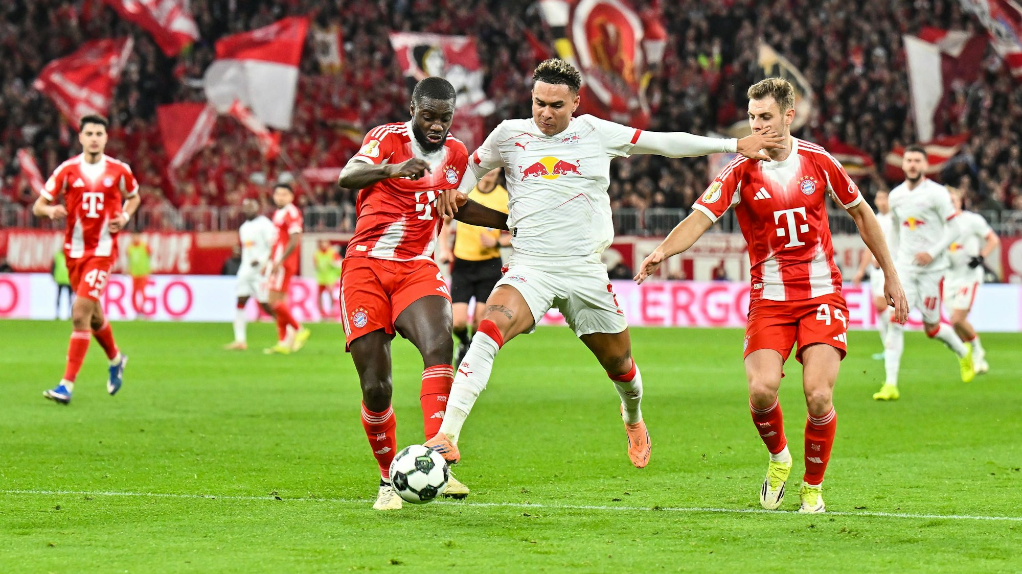 Dayot Upamecano (l.) und Antonio Nusa (M.) kämpfen um den Ball.