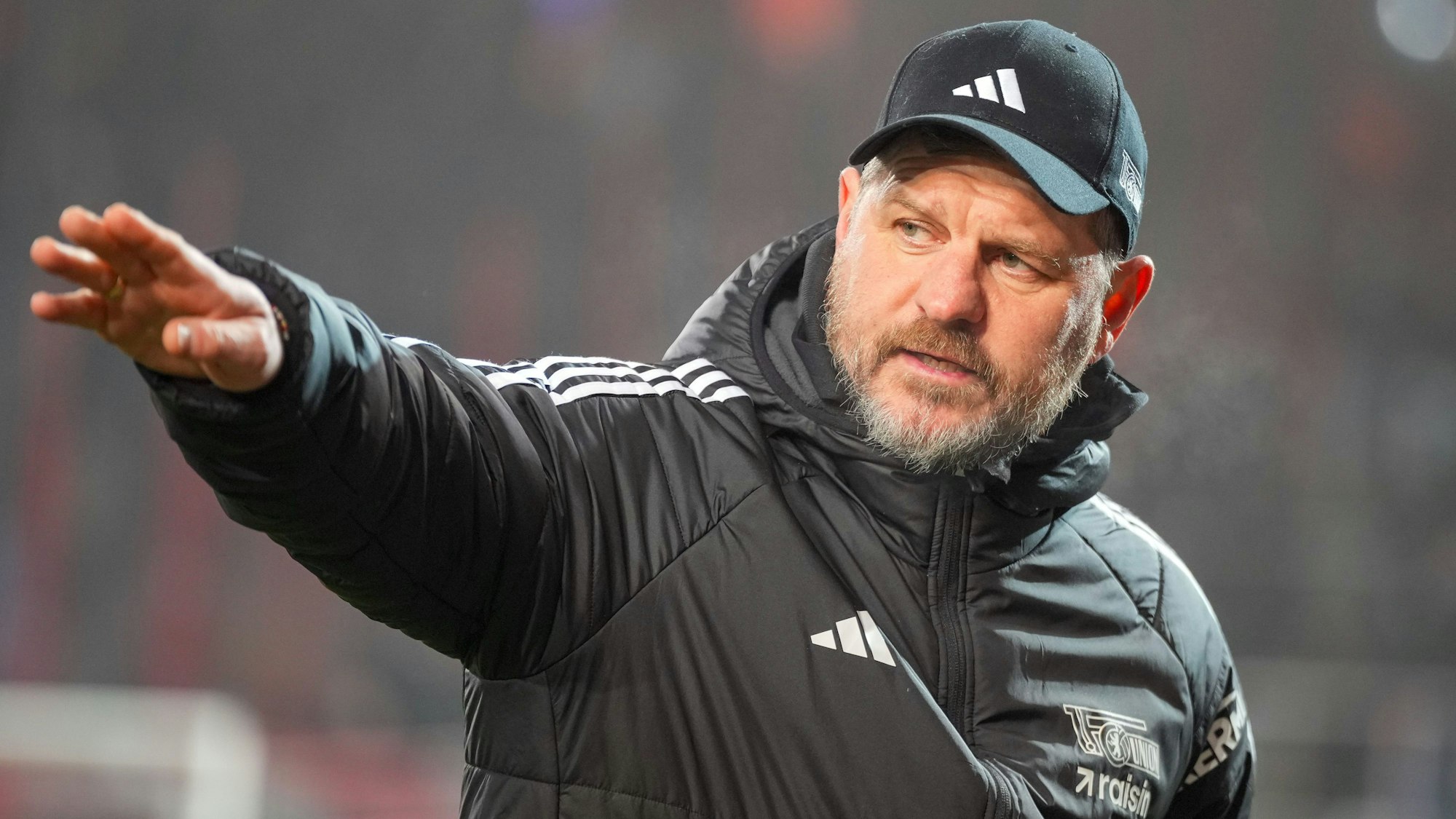 Trainer Steffen Baumgart unterhält sich vor dem Spiel mit einem Gast.