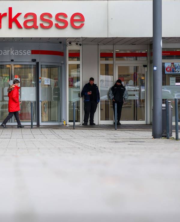 Security-Mitarbeiter stehen vor der Sparkasse Gelsenkirchen, die auf dem Archivbild noch geschlossen ist. Vier Fehlalarme sorgen aktuell für Einsätze.