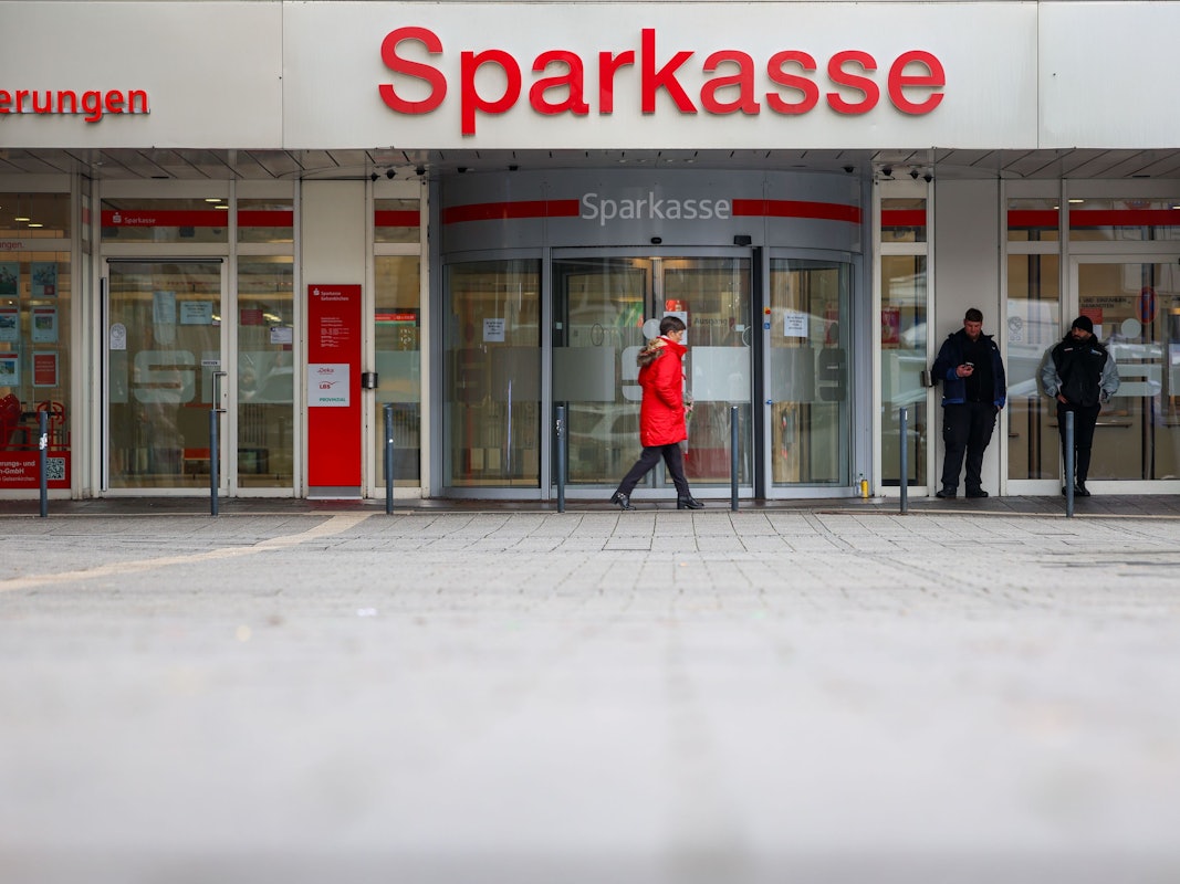 Security-Mitarbeiter stehen vor der Sparkasse Gelsenkirchen, die auf dem Archivbild noch geschlossen ist. Vier Fehlalarme sorgen aktuell für Einsätze.