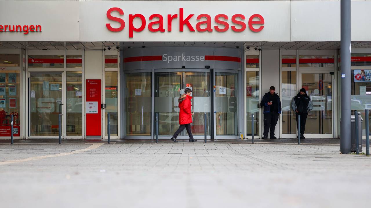 Security-Mitarbeiter stehen vor der Sparkasse Gelsenkirchen, die auf dem Archivbild noch geschlossen ist. Vier Fehlalarme sorgen aktuell für Einsätze.