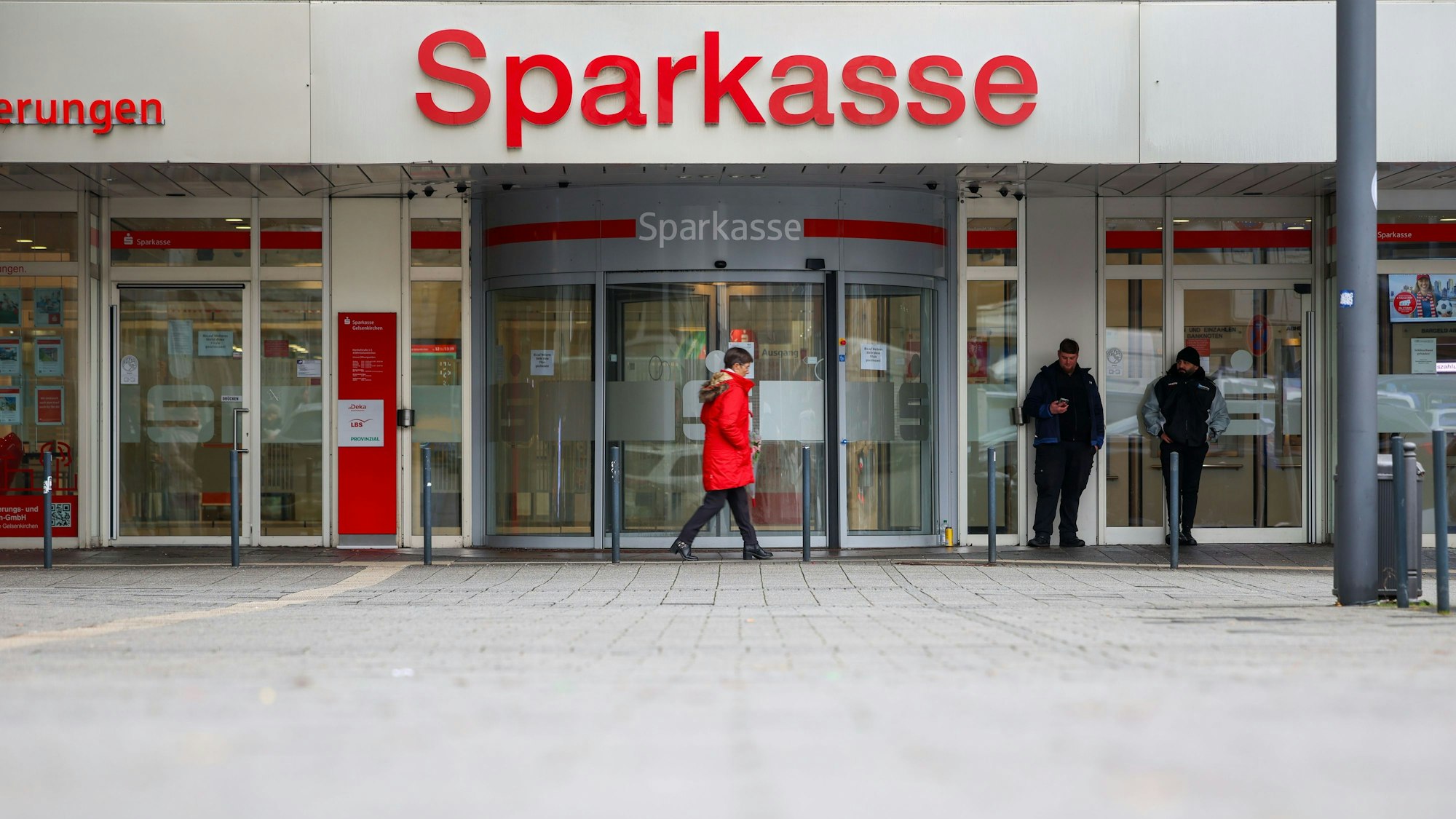 Security-Mitarbeiter stehen vor der Sparkasse Gelsenkirchen, die auf dem Archivbild noch geschlossen ist. Vier Fehlalarme sorgen aktuell für Einsätze.