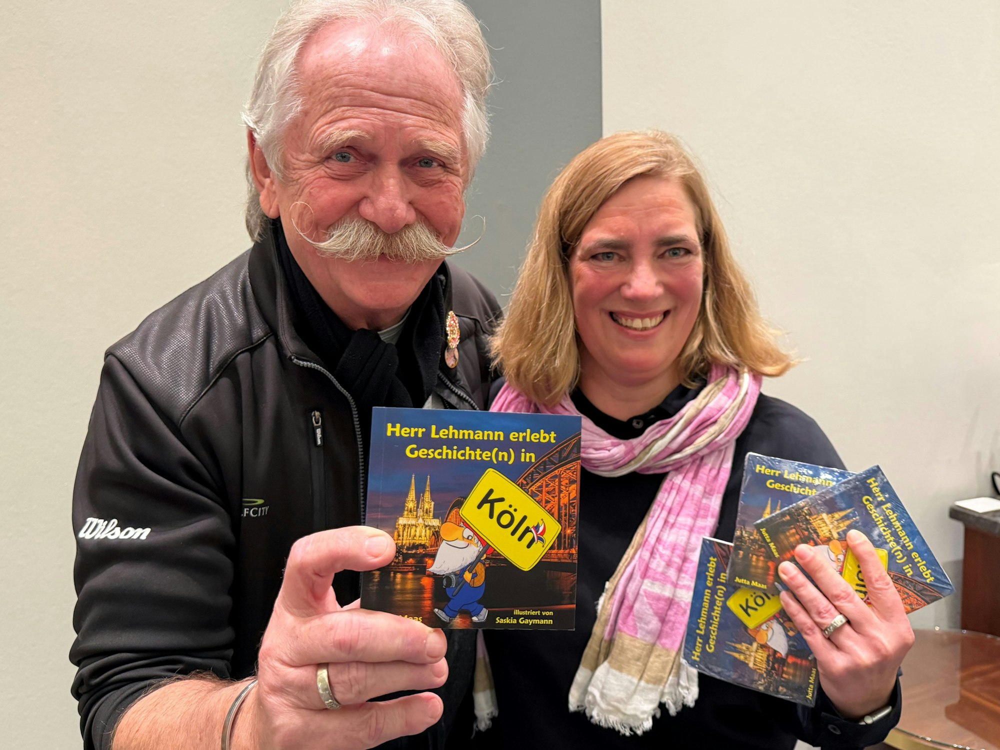 Henning Krautmacher zeigt Bücher mit Annette Kramer.