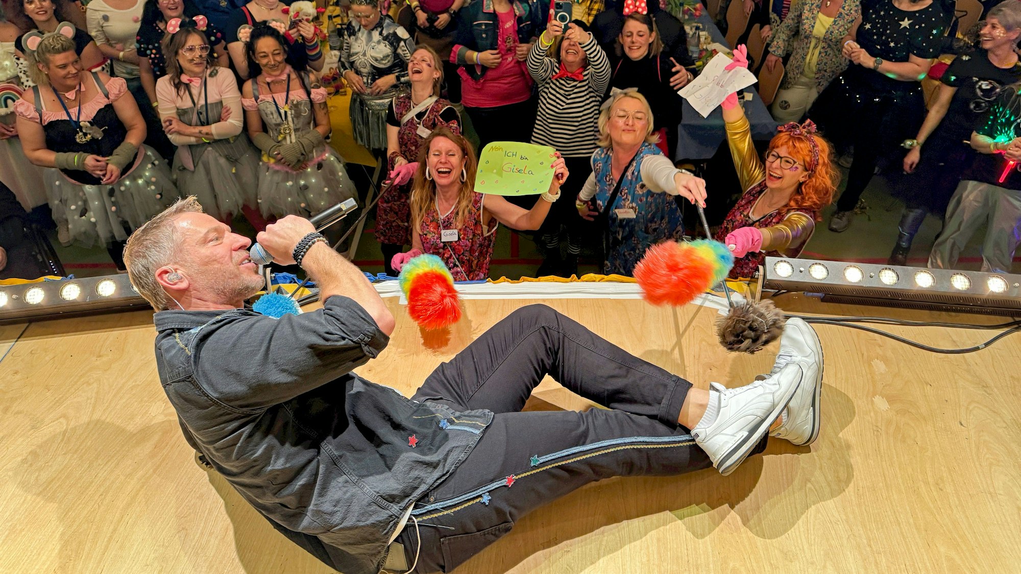 Patrick Lück liegt beim Singen auf der Bühne.