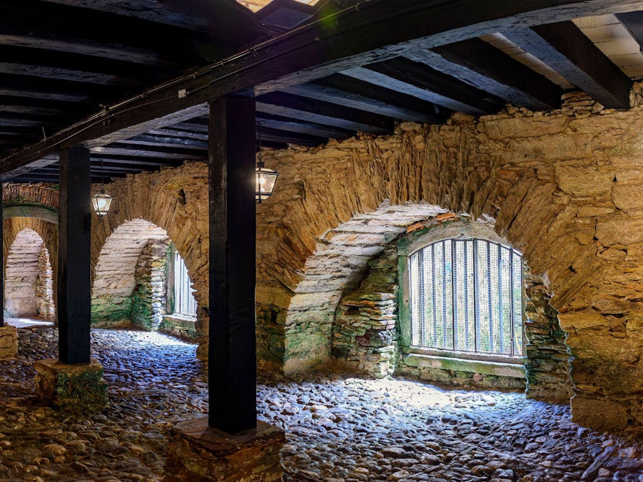 Steinmauerwerk, Bögen, Holzbalken, Laternen und Pflasterboden