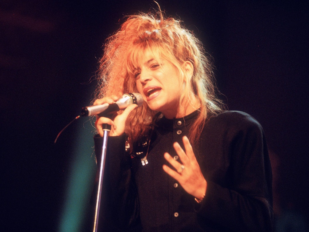 Taylor Dayne singt in ein Mikro.