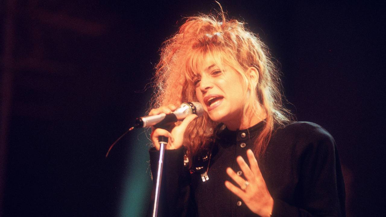 Taylor Dayne singt in ein Mikro.