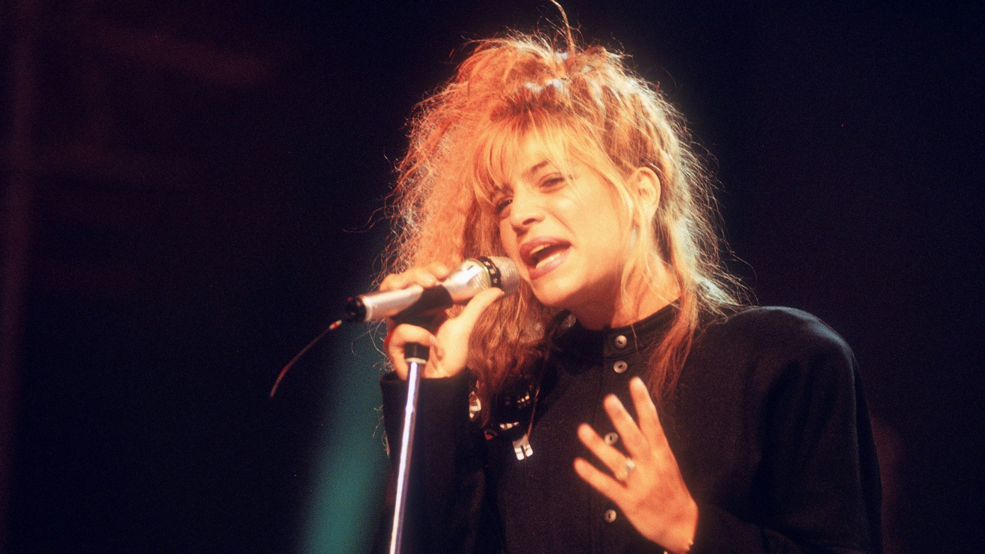 Taylor Dayne singt in ein Mikro.