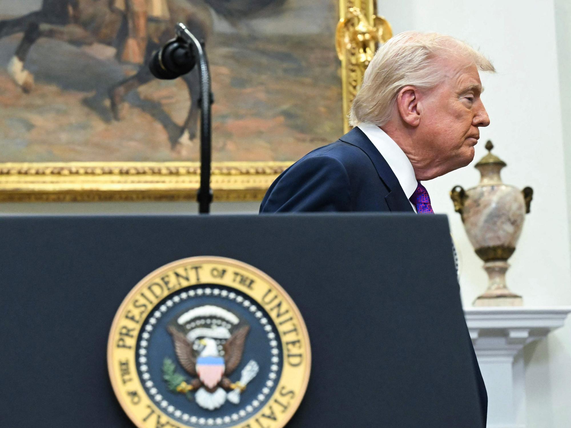 Donald Trump verlässt mit geschlossenen Augen ein Rednerpult.