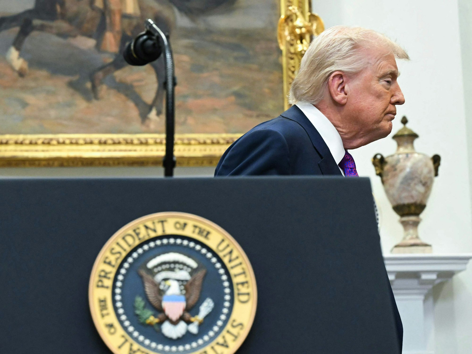 Donald Trump verlässt mit geschlossenen Augen ein Rednerpult.