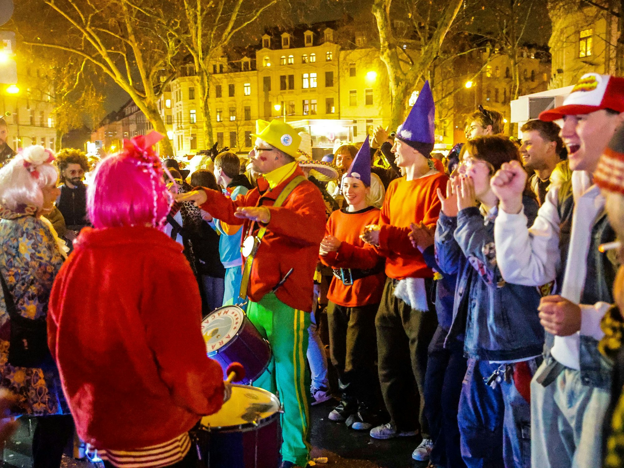 Menschen schlagen auf Trommeln, anderen singen.