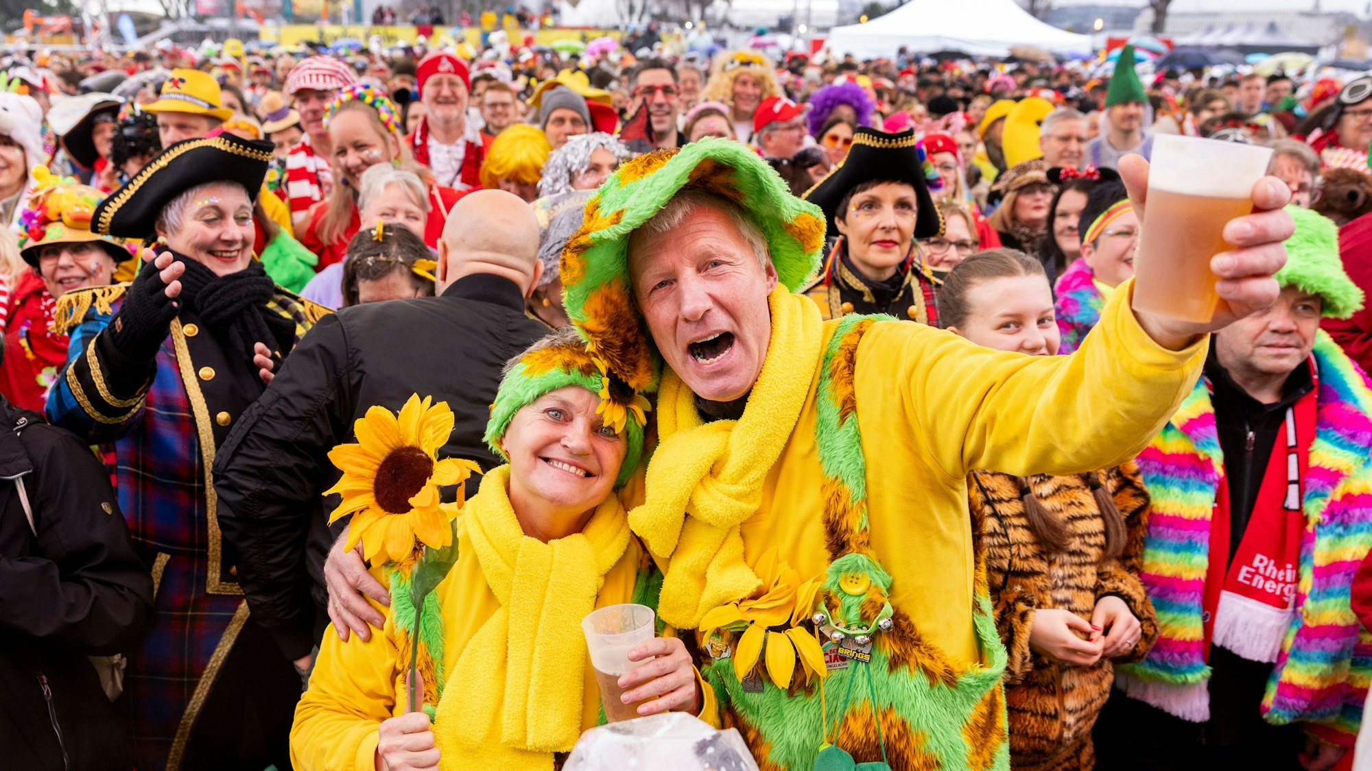 Ein Paar ist als Sonnenblume verkleidet und steht vor einer Menschenmenge.