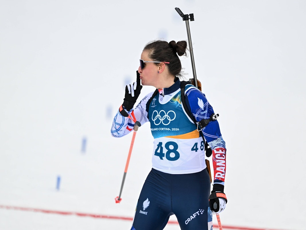 Julia Simon legt sich nach Olympia-Gold im Biathlon den Zeigefinger auf die Lippen.