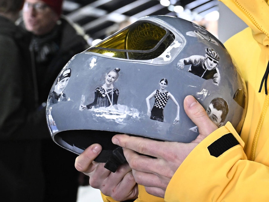 Vladyslav Heraskevych hält einen Helm mit Sportlerbildern