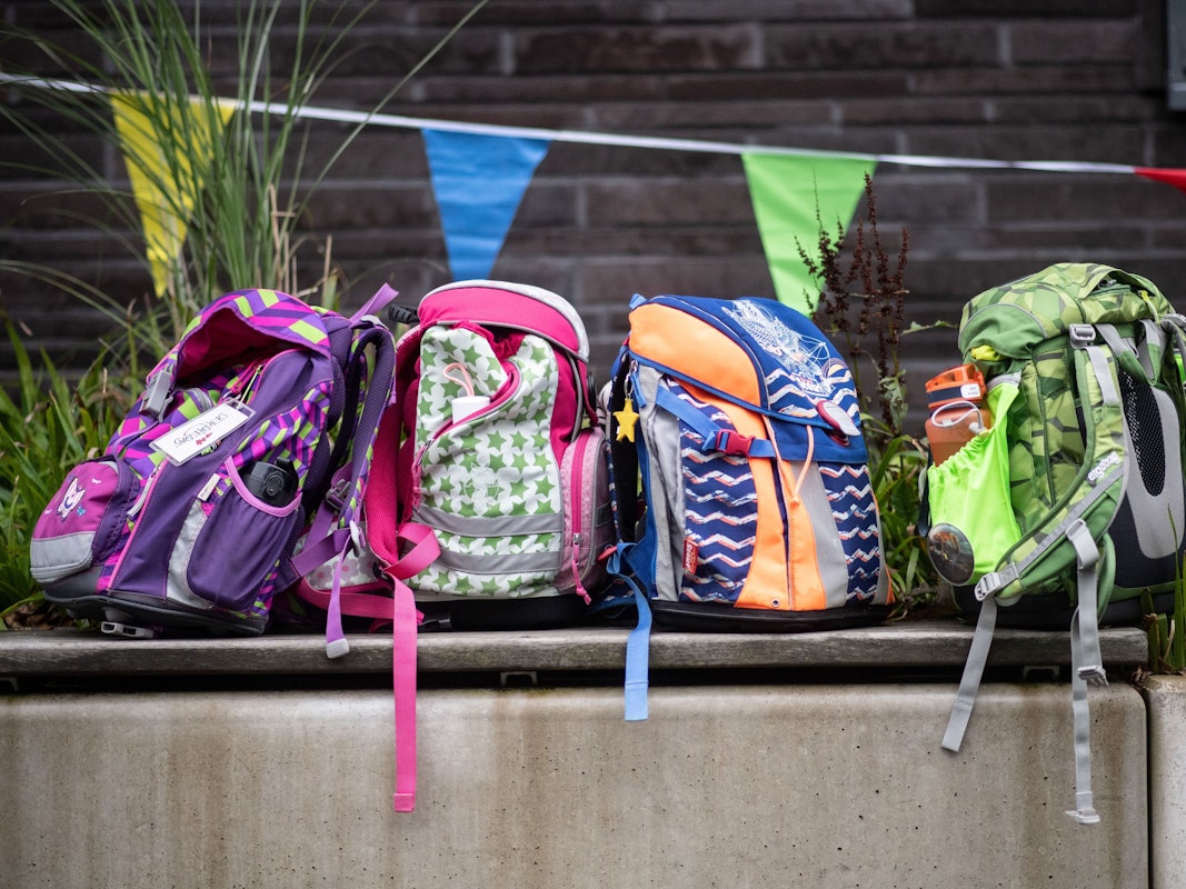 ARCHIV - 18.08.2021, Nordrhein-Westfalen, Wuppertal: ILLUSTRATION: Vier Schulranzen stehen auf einer Bank. (zu dpa: «Umfrage: Ganztag für viele Schulleitungen nicht machbar») Foto: Bernd Thissen/dpa +++ dpa-Bildfunk +++