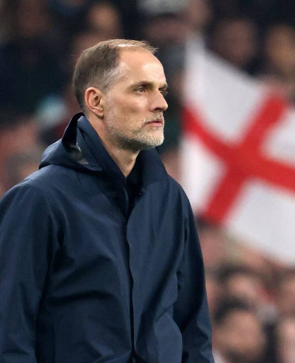 Thomas Tuchel schaut aufs Spielfeld, im Hintergrund ist eine England-Flagge zu sehen.