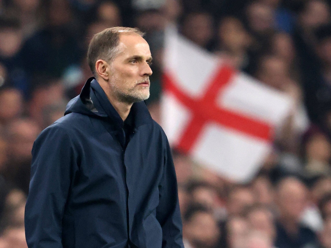 Thomas Tuchel schaut aufs Spielfeld, im Hintergrund ist eine England-Flagge zu sehen.