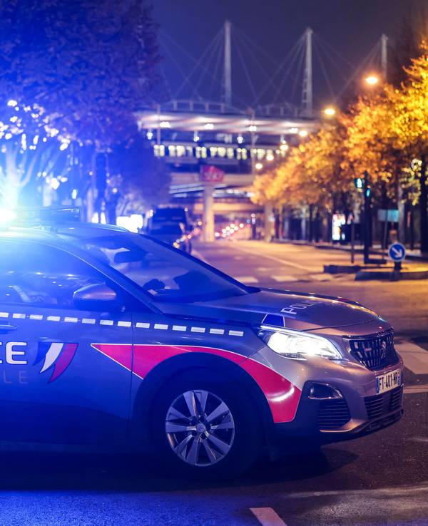 Ein Polizeiauto mit angeschaltetem Blaulicht steht auf einem Parkplatz.