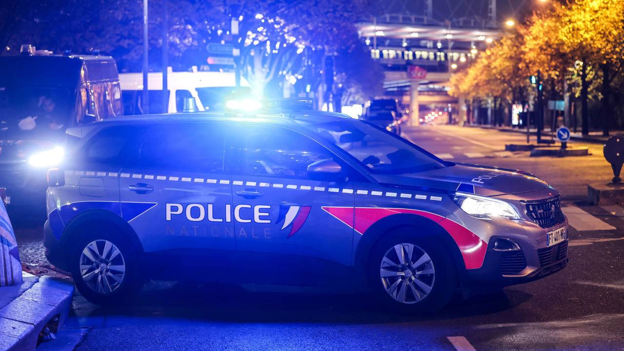 Ein Polizeiauto mit angeschaltetem Blaulicht steht auf einem Parkplatz.