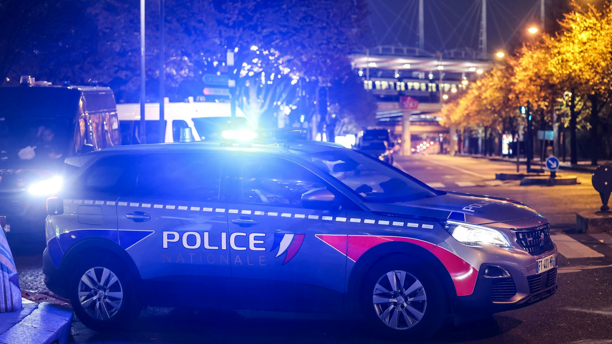 Ein Polizeiauto mit angeschaltetem Blaulicht steht auf einem Parkplatz.