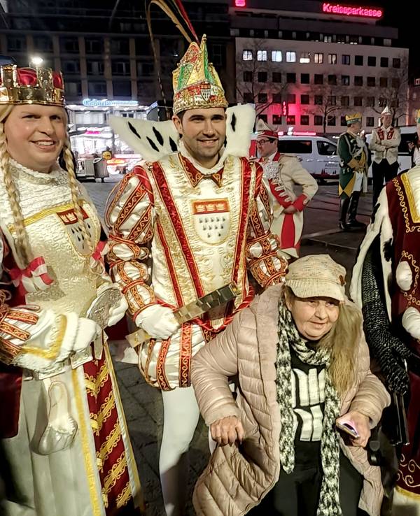 Eine alte Dame posiert mit dem Kölner Dreigestirn.